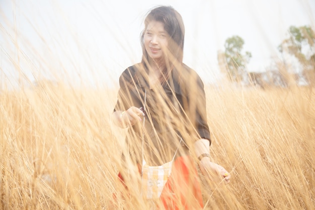 Asian women black shirt. Standing in a meadow.