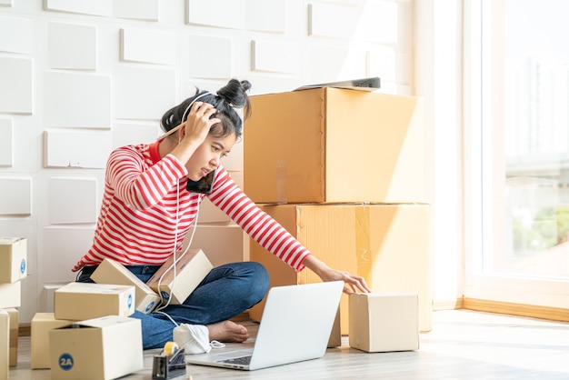 Imprenditore di donne asiatiche che lavora a casa con scatola di imballaggio sul posto di lavoro - imprenditore di pmi dello shopping online o concetto di vendita online