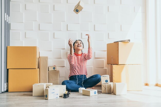 Asian Women business owner working at home with packing box on workplace