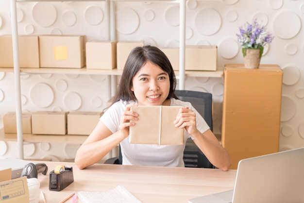 Asian Women business owner working at home with packing box on workplace