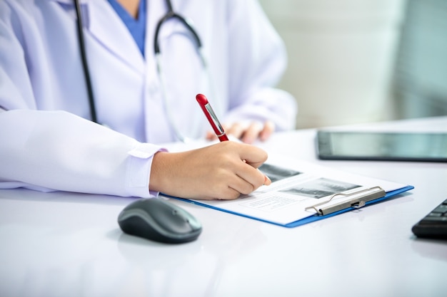 Asian women doctor  working and analyzing x-ray images  at  hospital office