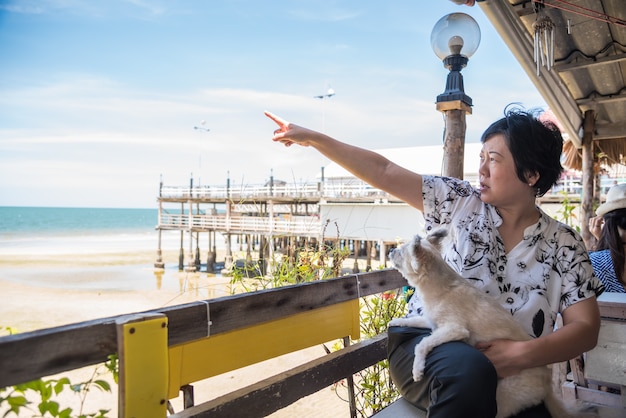 旅行の際にビーチや海でアジアの女性と犬