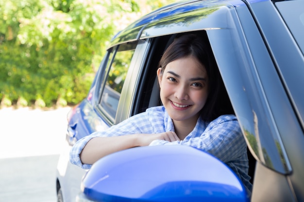 Asian women driving a car and smile happily