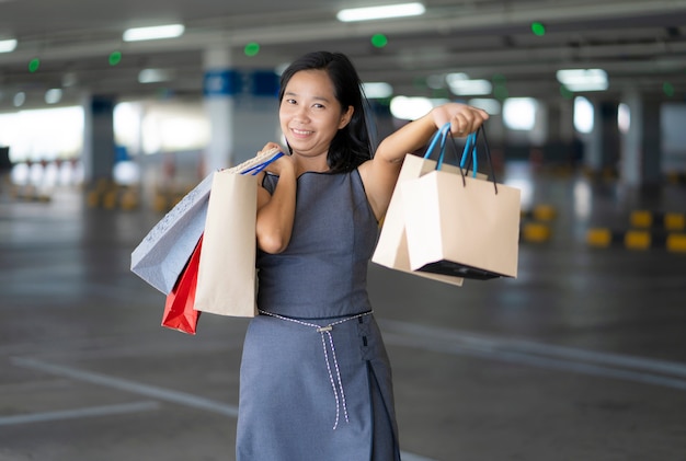 アジアの女性はショッピングモールで買い物を楽しむ