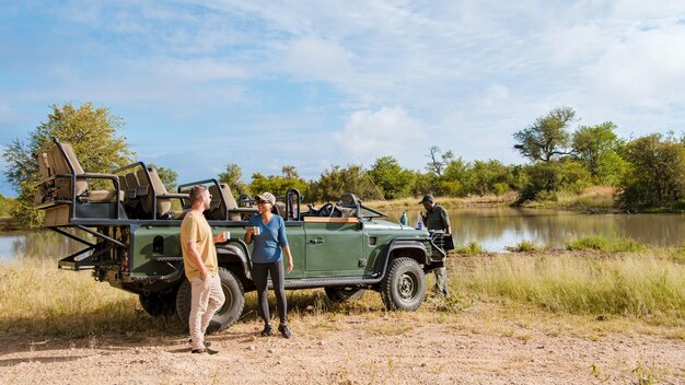 Photo asian women and european men on safari game drive in south africa kruger national park