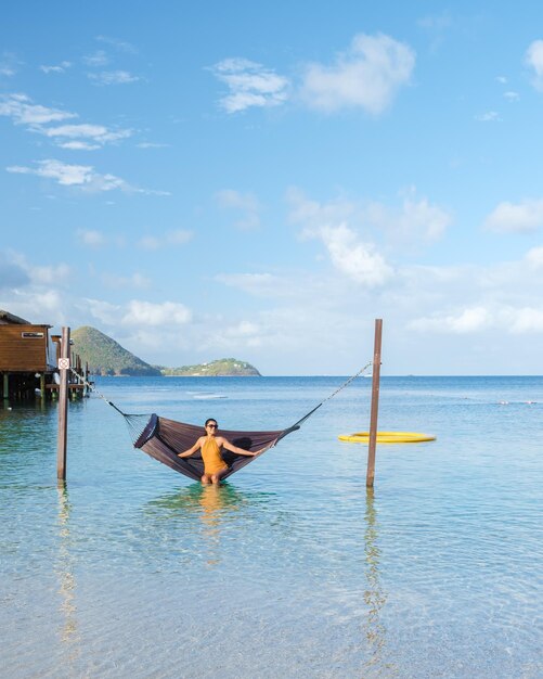 Asian women in hammock on the beach of the tropical island\
saint lucia or st lucia caribbean