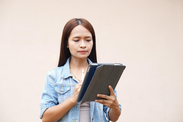 Asian women happily use portable computers because the operating results are more profitable