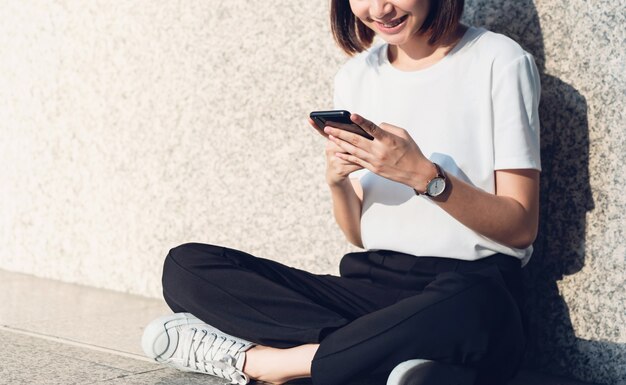 Asian women of happy smiling sitting using smartphone.