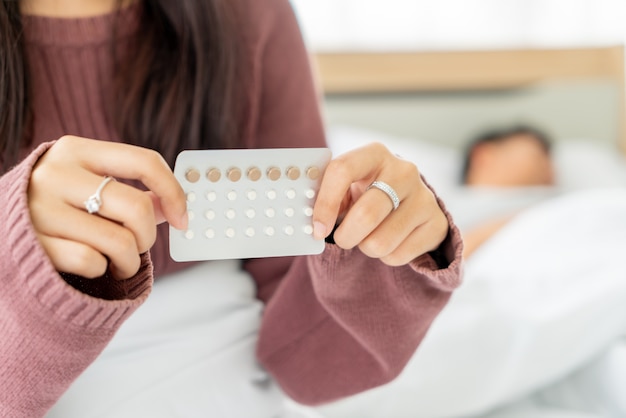 Photo asian women holding birth control pill