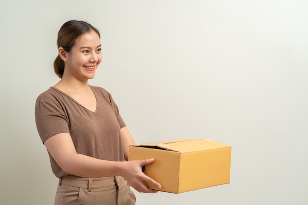 Asian women holding parcel box package shipment service and\
delivery courier concept