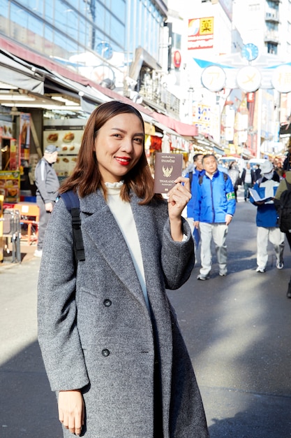 Asian women holding passport in city