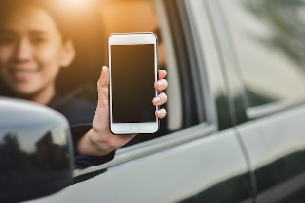 Asian  women holding smartphone in car