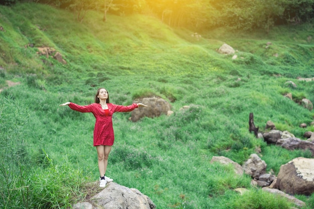 写真 日の出に赤いドレスのアジア女性