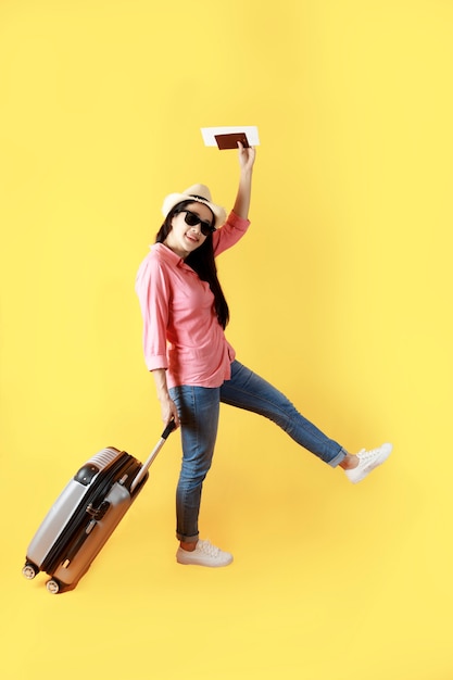 Asian women long hair wear Straw hat with black ribbon in hand holding passport book and travel bag.