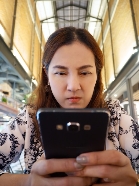 Asian women look at mobile phone and furious.