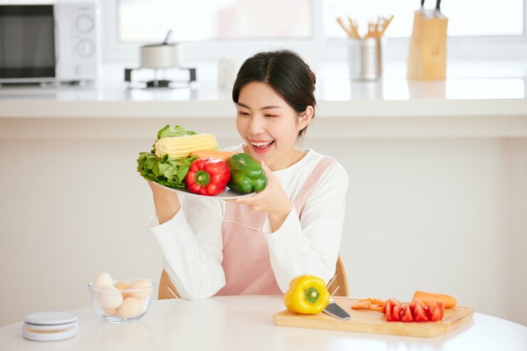 Photo 아시아 여성들은 신선한 과일 야채와 함께 식탁에서 휴식을 취합니다