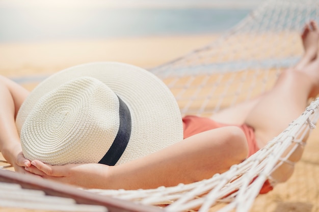 Asian women relaxing in hammock summer holiday on beach