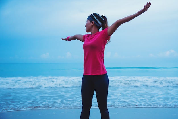 Asian women running workout jogging on the beach in the morning