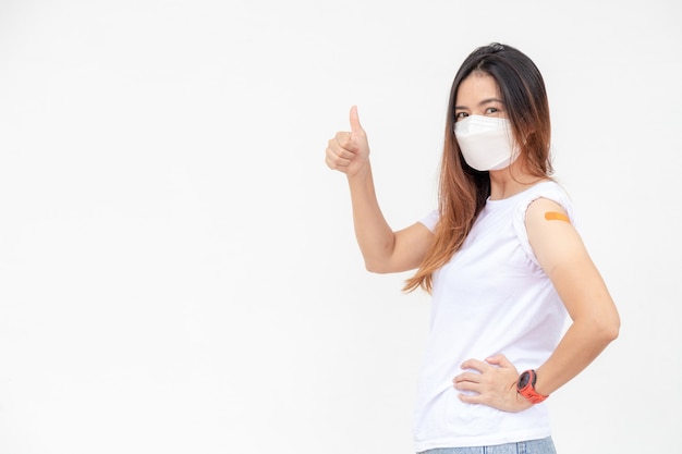 Asian Women Show Bandage On Arm. Happy Asian Woman Feels Good After Received Vaccine On White Background.Thumb up.