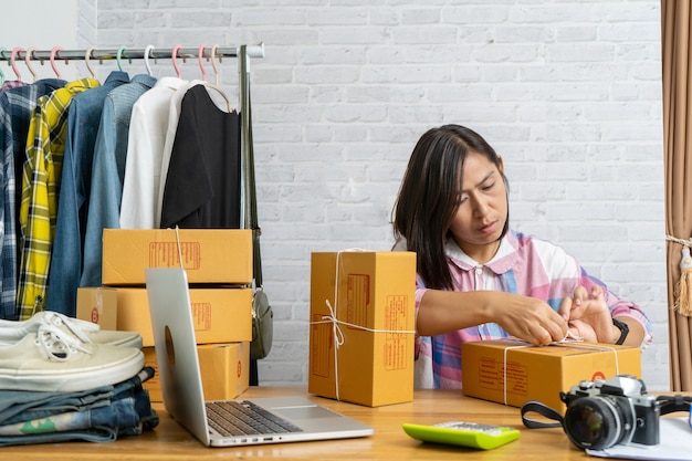 Asian women start up small business owner packing cardboard box