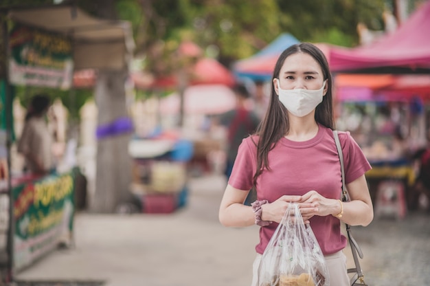 코로나 바이러스 잠금 해제 후 거리 시장 새로운 일반 리프트에서 아시아 여성 태국 사람들이 얼굴 마스크 쇼핑 사용