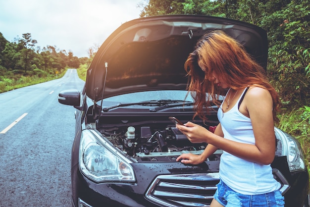 アジアの女性旅行は休日にリラックスします。通りに壊れた車。タイ