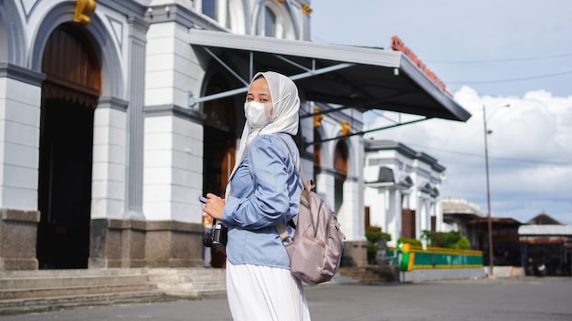 駅前を電車で旅するアジア人女性