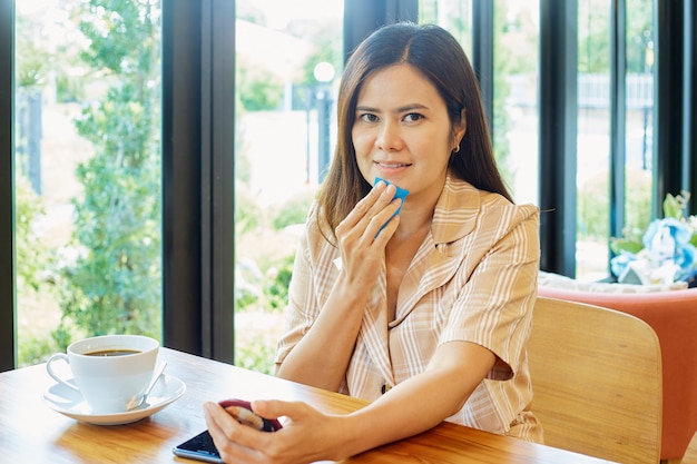 Le donne asiatiche usano un film di olio detergente per sbarazzarsi di oli per il viso e trucco nel soggiorno di casa. pelle liscia e sana. concetto di bellezza