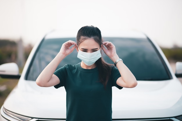 Фото Азиатские женщины используют хирургическую маску или маску на дороге, припаркованной на улице