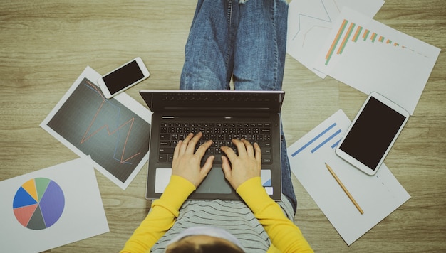 Asian women wearing masks working at home or work remotely using smartphone to reduce spreading of coronavirus infection during Covid-19 outbreak.