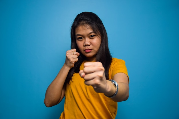 파란색 고립 된 배경을 가진 아시아 여성 싸움 개념 제스처 싸움 주먹 펀치