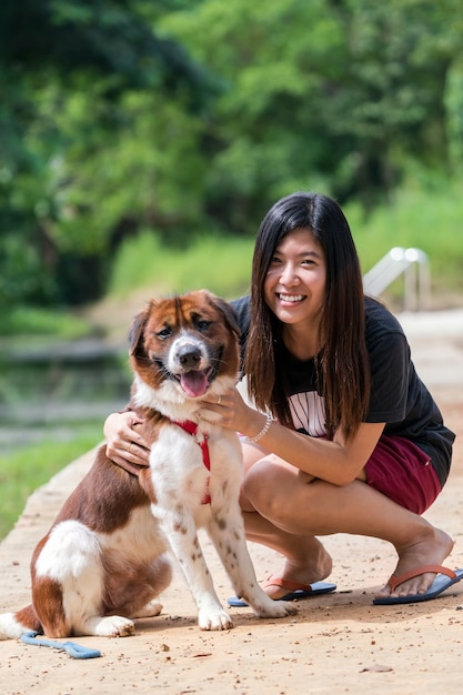 茶色の混合犬を持つアジアの女性