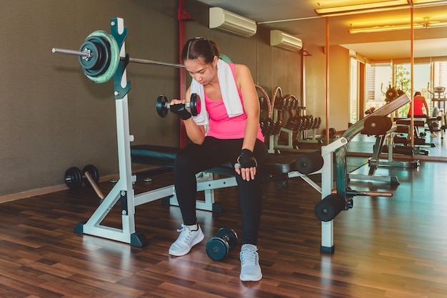 Asian women workout lifting a dumbbell in the gym In the morning, fresh