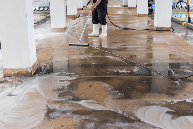 Asian worker cleaning sand wash exterior walkway