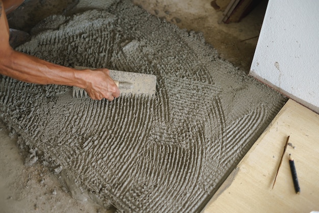 Asian worker laying floor tiles