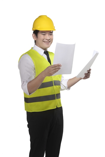 Asian worker wearing safety vest and yellow helmet holding blueprint