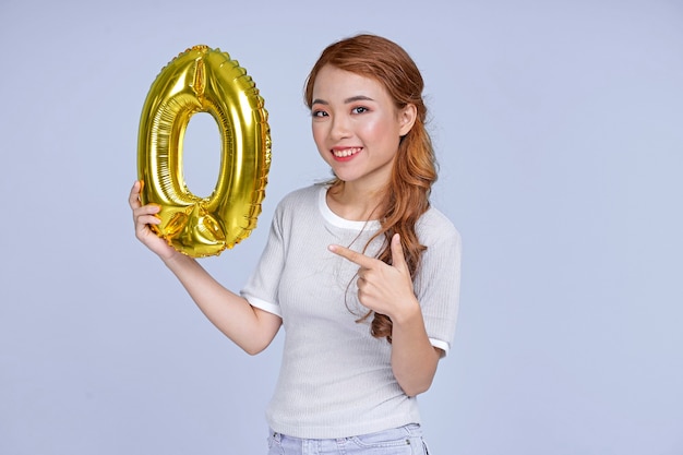 Asian young attractive beautiful young girl holding metallic foil balloon number