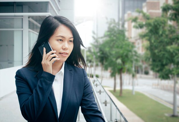 Photo asian young business woman using smartphone