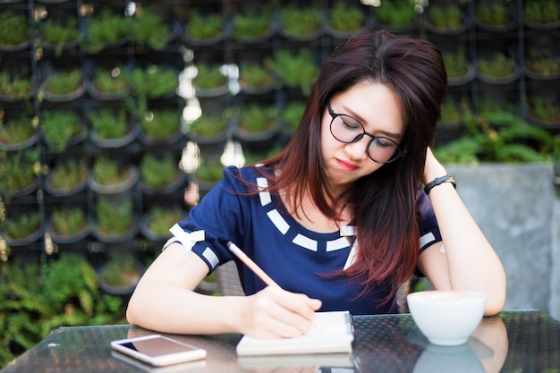 Asian young business woman write a note 