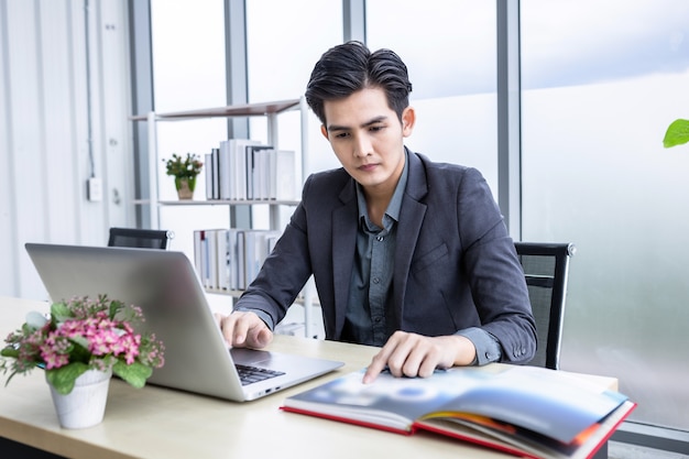 asian young businessman see a successful business plan on the laptop computer