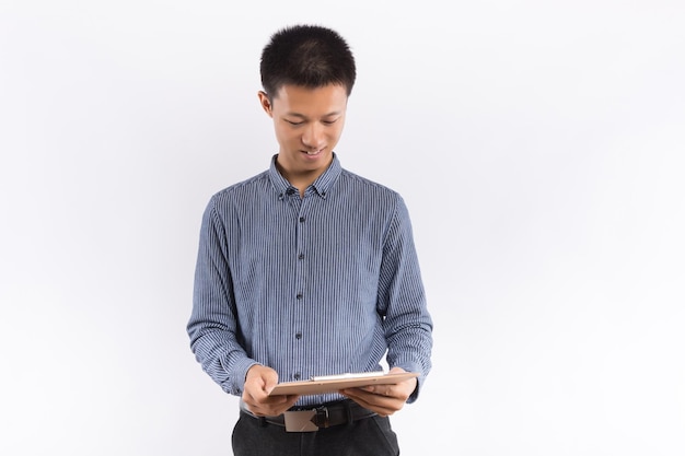 Asian Young Businessman take note on clipboard