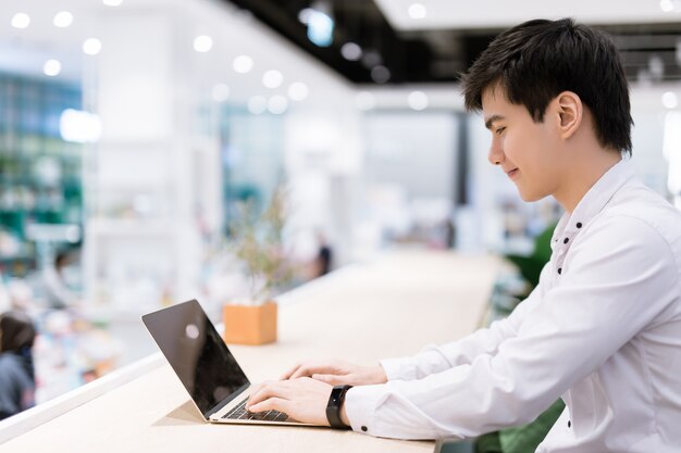 Asian young businessman using laptop at his office desk