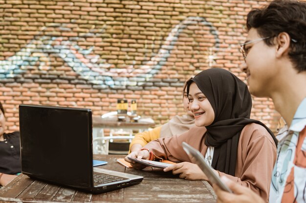 Asian young couple using her laptop and tablet pc