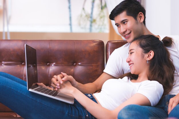 Giovani coppie asiatiche che per mezzo del computer portatile. concetto di amanti e coppie