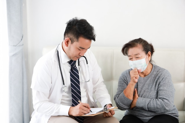 Asian young doctor talking with senior woman in hospital