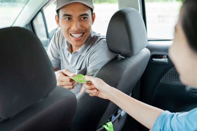 Asian young drivers kindly approve payment by credit card