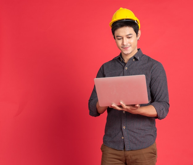 Asian young engineer man hold laptop