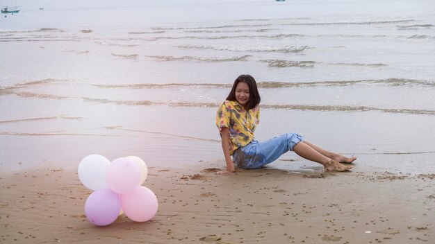 Asian young girl enjoy time playing balloone at the beach