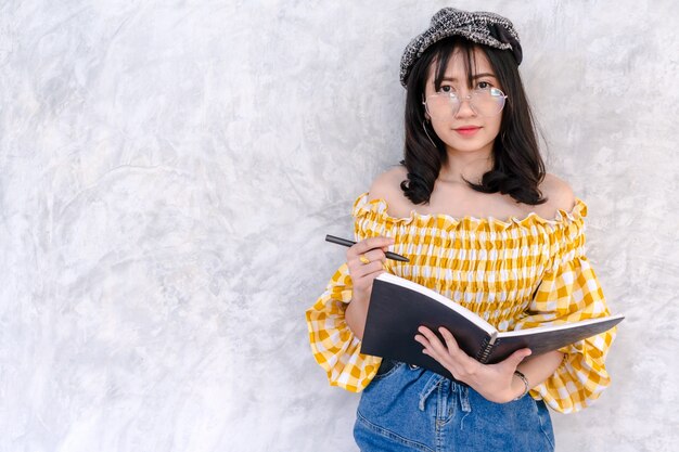 Asian young girl student positive attractive on wall background