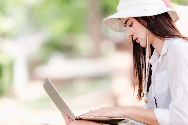 Asian young girls traveler in city,Women sitting use laptop search for attractions